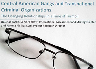 Reading glasses lying on a copy of Douglas Farah's publication Central American Gangs and Transnational Criminal Organizations